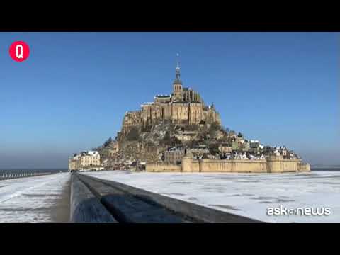 Il sole splende su Mont-Saint-Michel coperta di neve