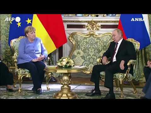 Vladimir Putin incontra Angela Merkel e la accoglie con un mazzo di fiori