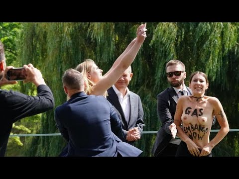 Il video delle due attiviste Femen che si spogliano davanti a Scholz per protesta: «Basta soldi…