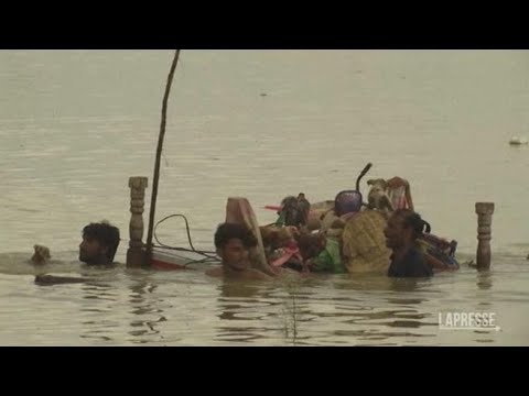 Alluvioni in Pakistan, persone guadano le acque per mettersi in salvo