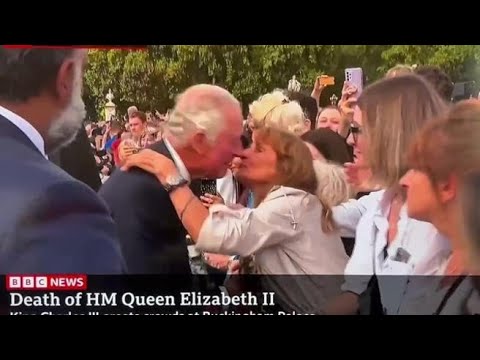 Re Carlo III saluta la folla a Buckingham Palace e una donna lo saluta con un bacio