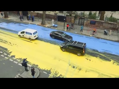 Attivisti dipingono la bandiera dell’Ucraina davanti all’ambasciata russa a Londra