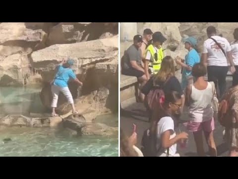 Una turista riempie la bottiglia con l’acqua della fontana di Trevi, a Roma