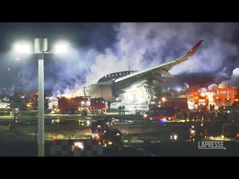 Il lavoro delle squadre di soccorso per spegnere l’incendio sulla pista dell’aeroporto di Tokyo