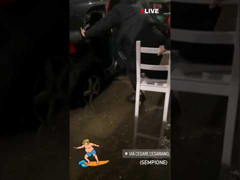 Allagamenti a Milano: per entrare in auto la donna è costretta alle acrobazie #shorts #news
