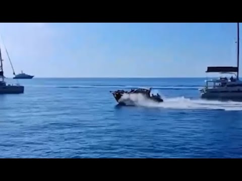 Sfreccia a tutta velocità tra le barche ferme in rada vicino alla scogliera di Capri