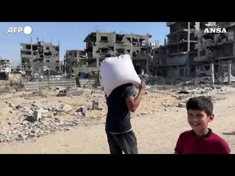 Gaza, civili palestinesi dopo l’arrivo di un carico di aiuti a Beit Lahia