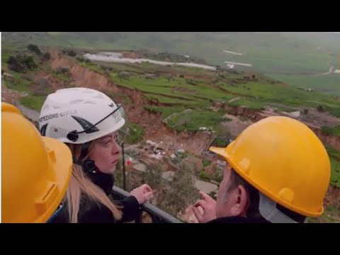 La premier Meloni (con il caschetto della protezione civile) visita Niscemi e le aree colpite dal…