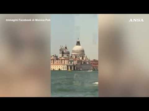 In piedi sopra un vaporetto, bravata nel centro di Venezia